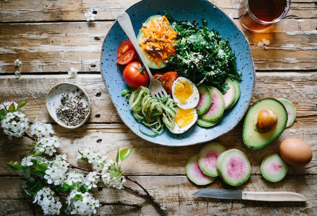 a plate of fresh healthy food on top of a dinner table